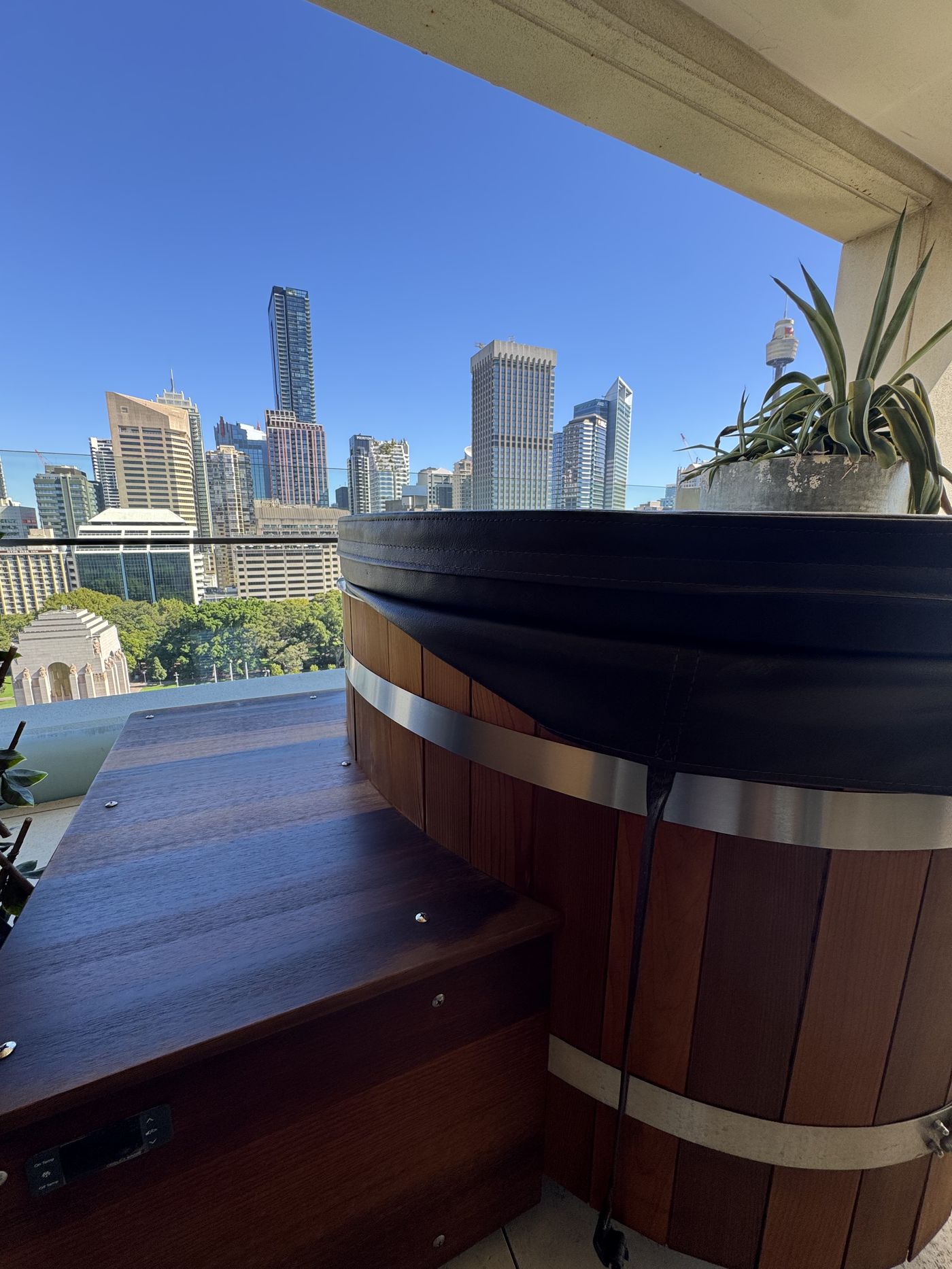 Wooden barrel ice bath installed on a Sydney CBD apartment balcony with skyline view