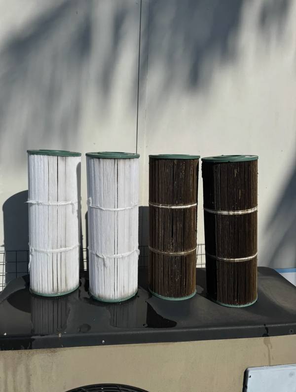 Clean cartridge filters next to dirty cartridge filters after pressure cleaning