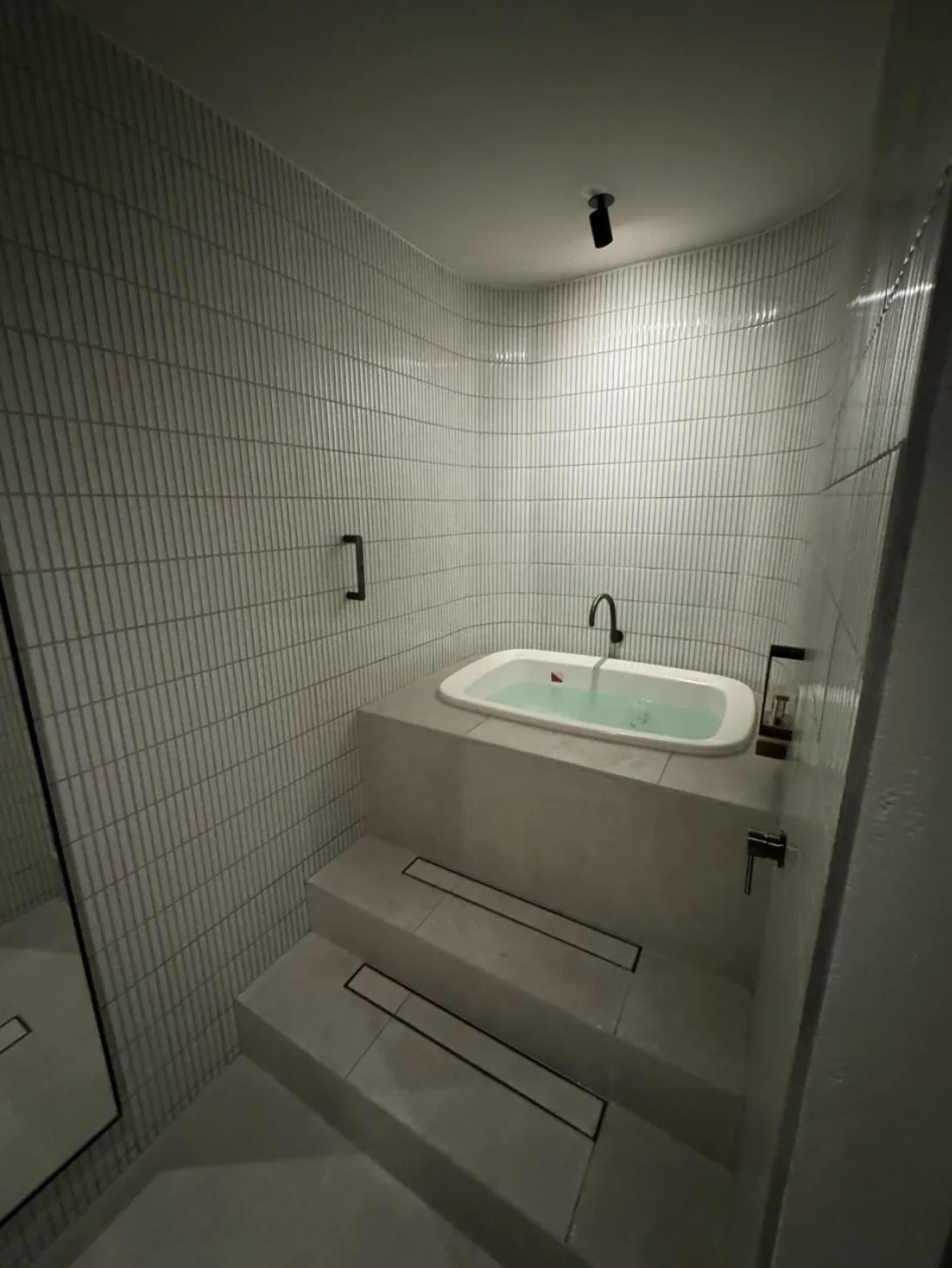 Built-in cold plunge with white finger tiles